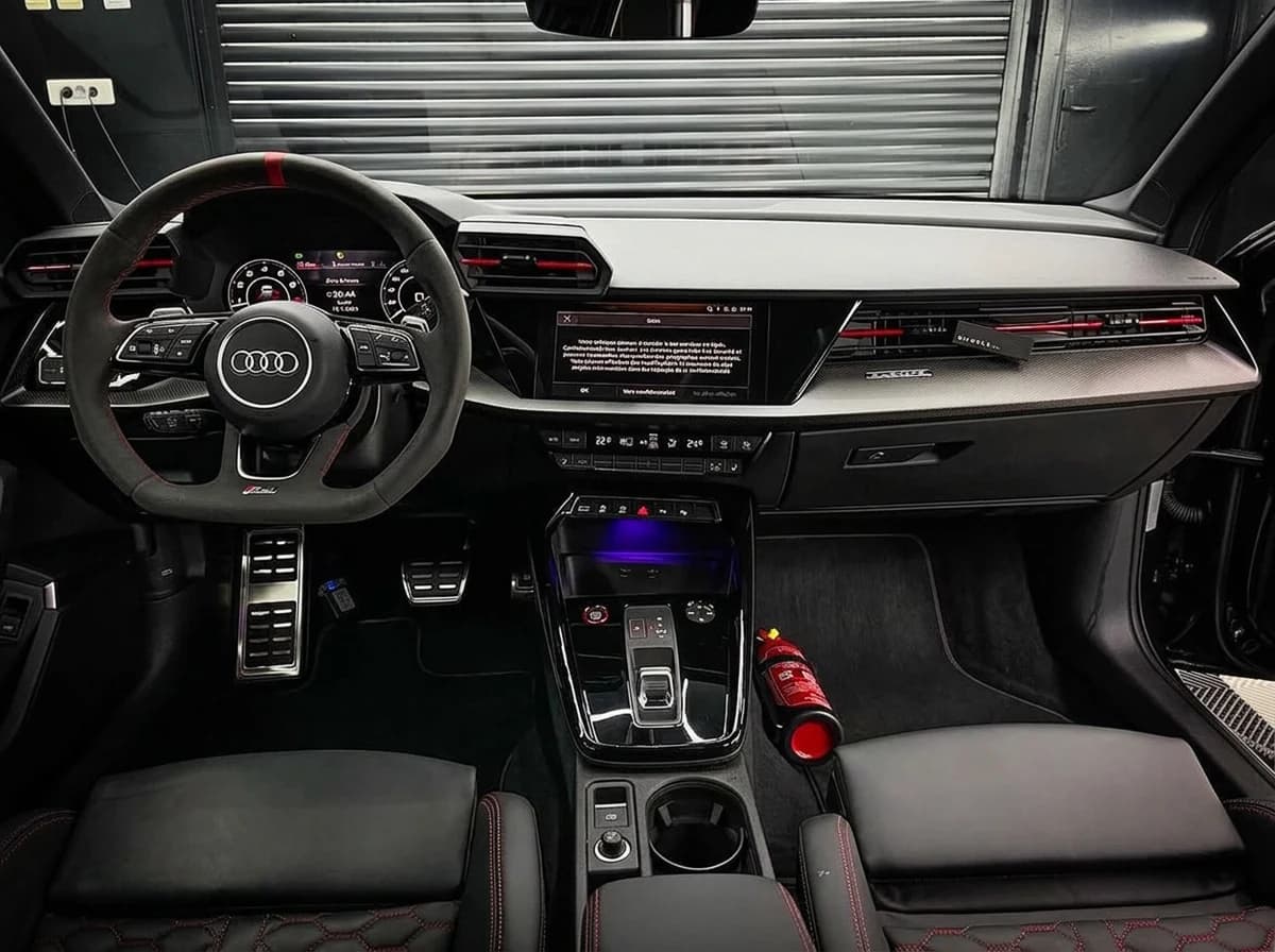 Planche de bord d'une Audi RS3 côté passager, volant RS, Virtual Cockpit et écran MMI allumés