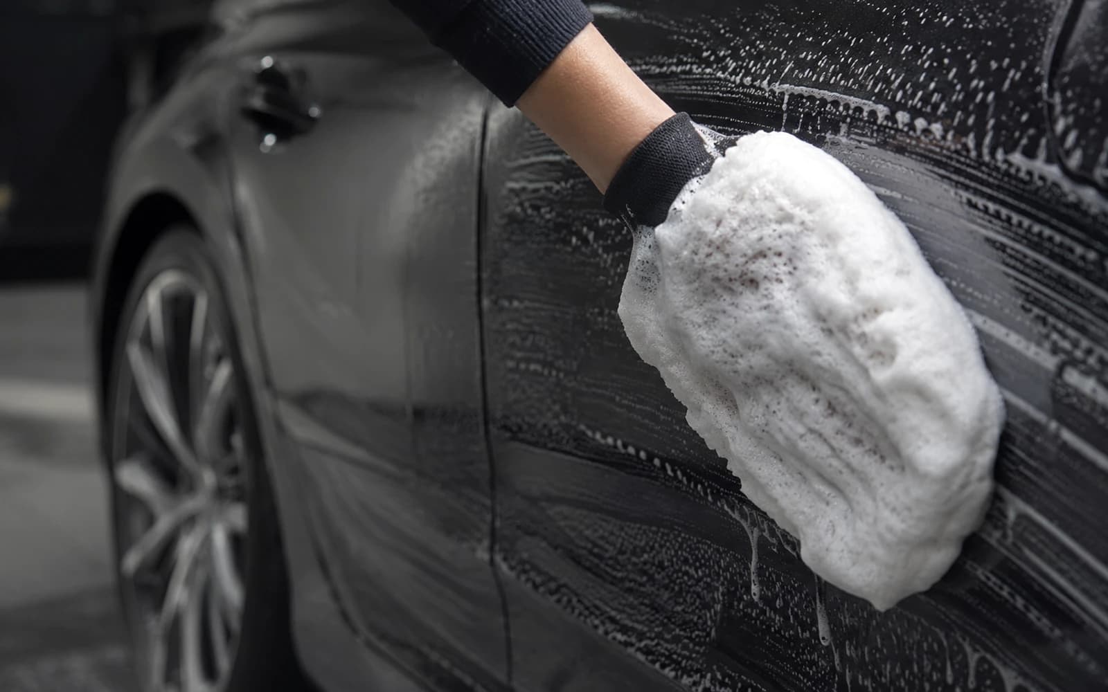 Illustration temporaire: Lavage manuel à la mousse d'une carrosserie sombre