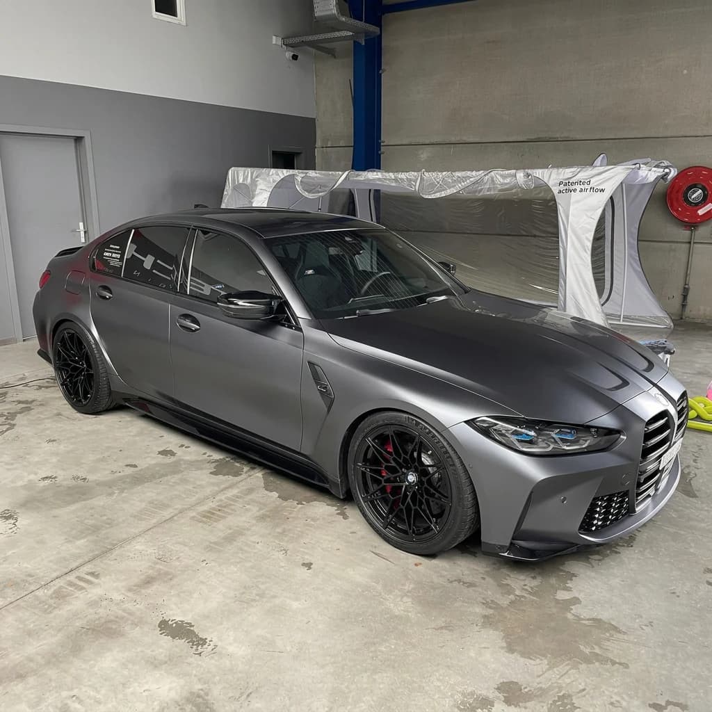 BMW M3 gris satiné mat de trois quarts avant dans l'atelier