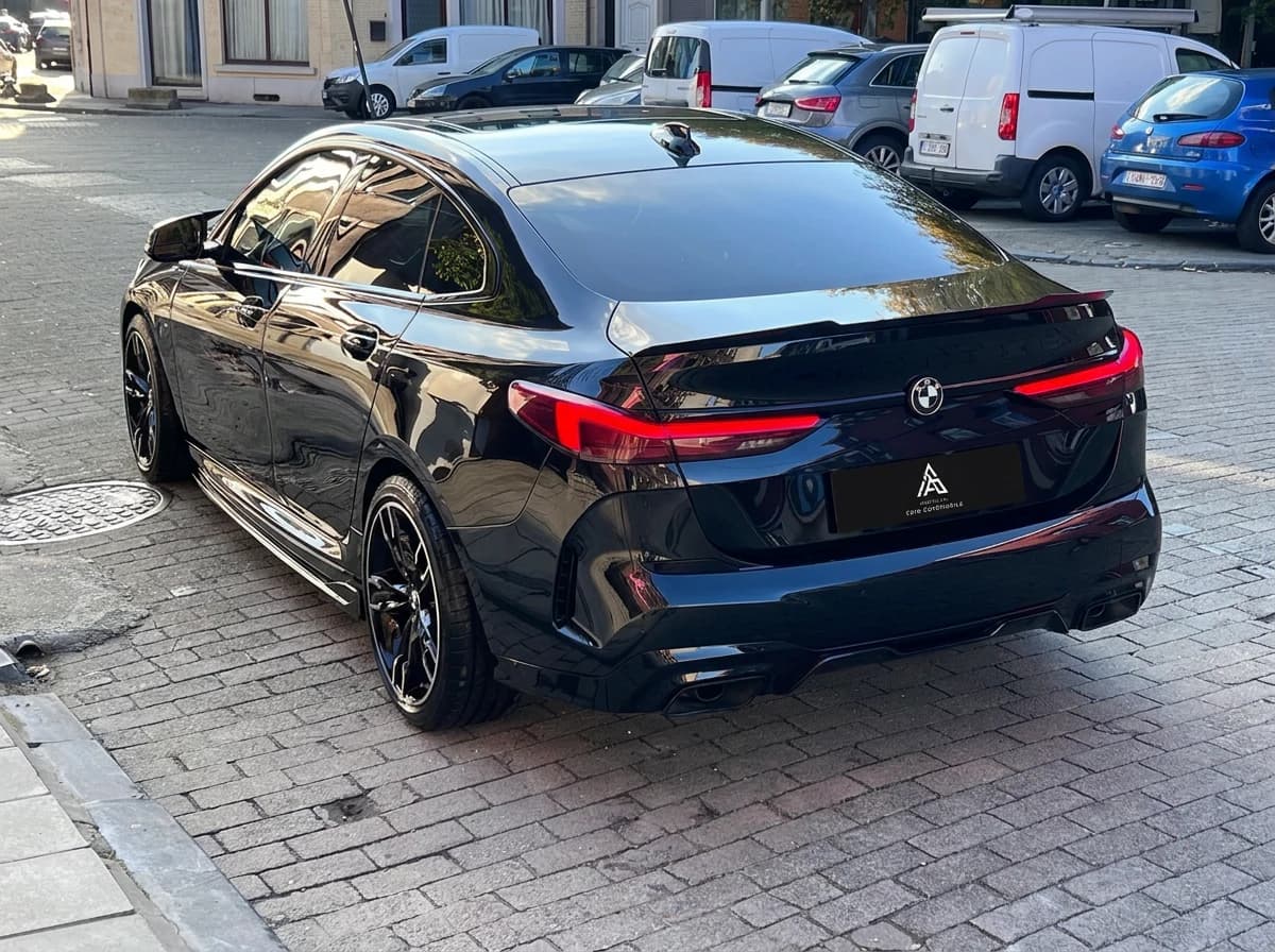 BMW Série 2 Gran Coupé noire de trois quarts arrière dans une rue pavée