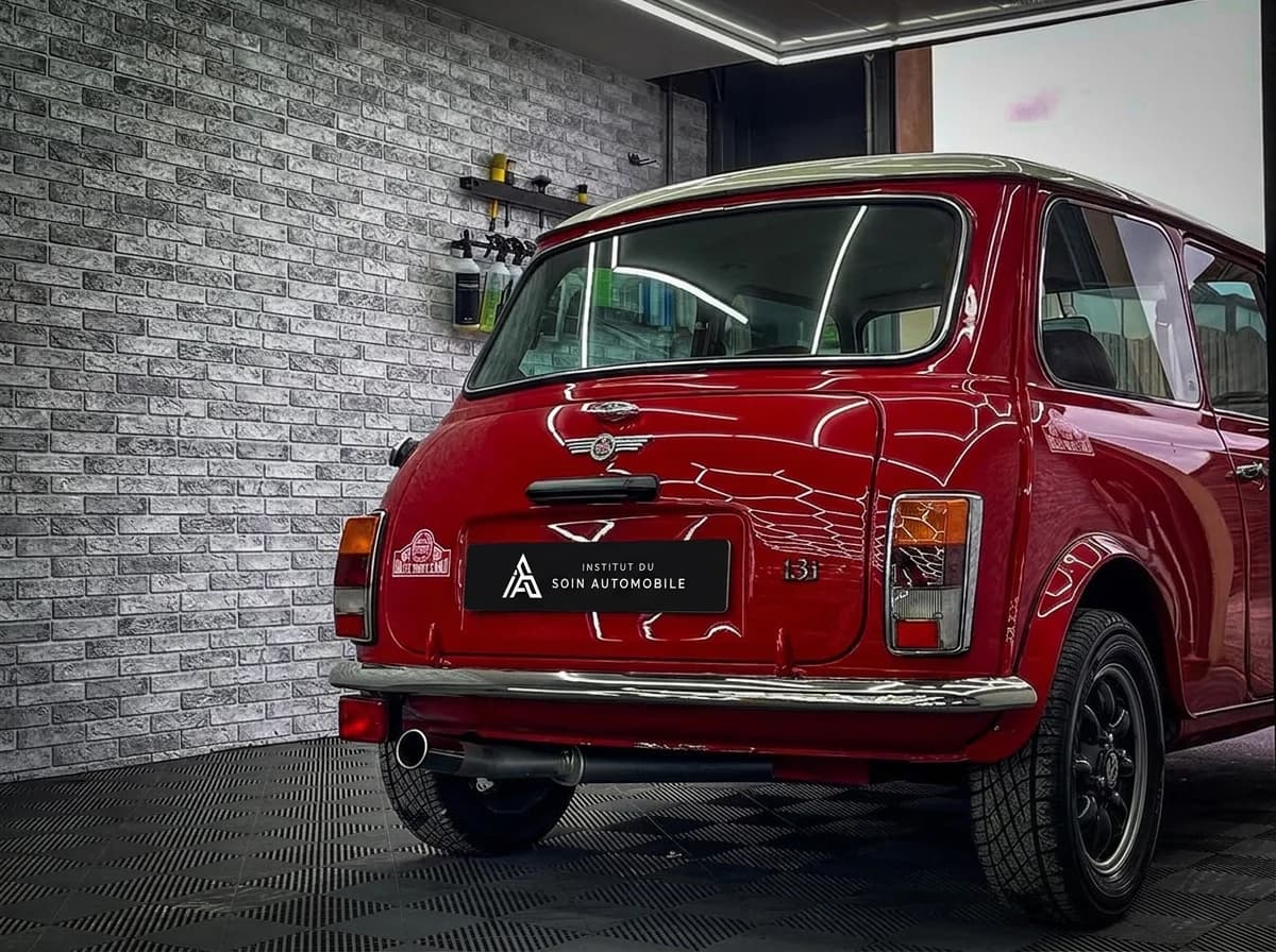 Mini classique rouge de trois quarts arrière dans l'atelier, mur en brique et sol à damier