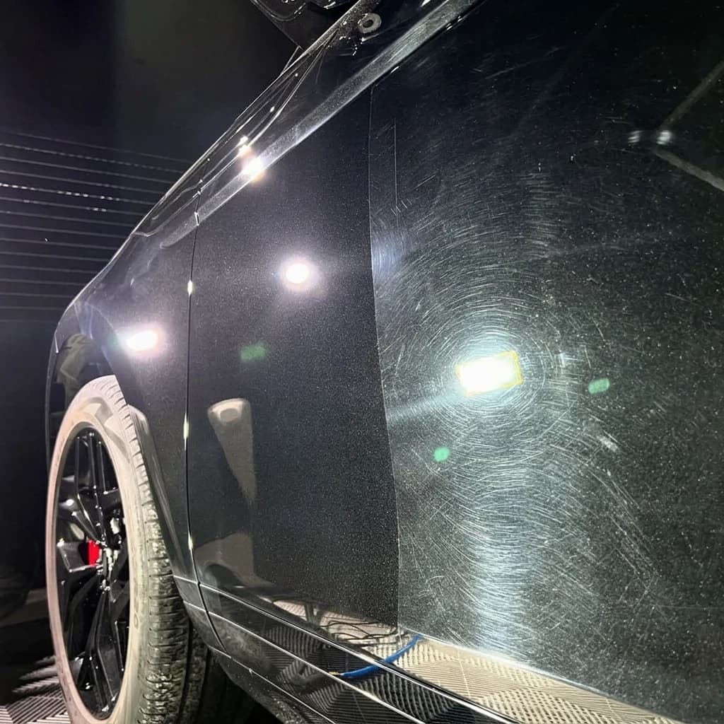 Micro-rayures et hologrammes révélés en lumière rasante sur une carrosserie noire chez ISA